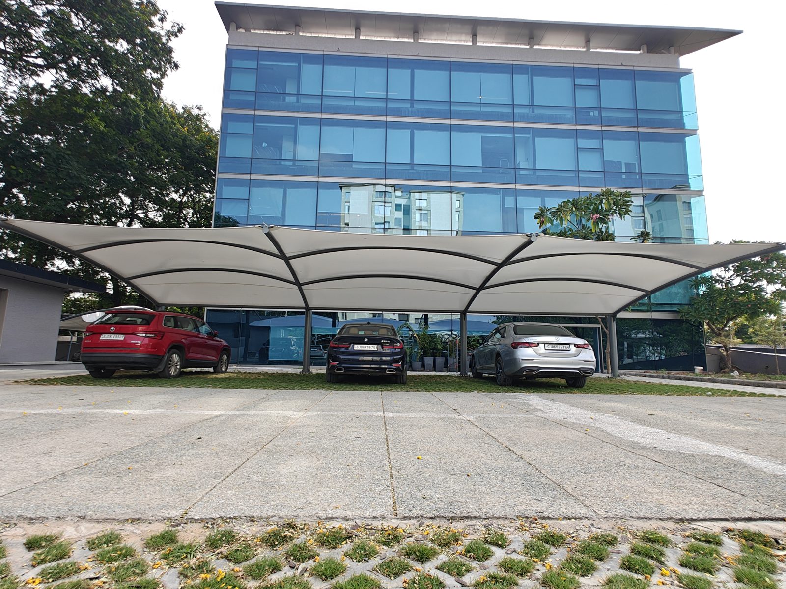 Cantilever parking canopy in front of a modern glass office building
